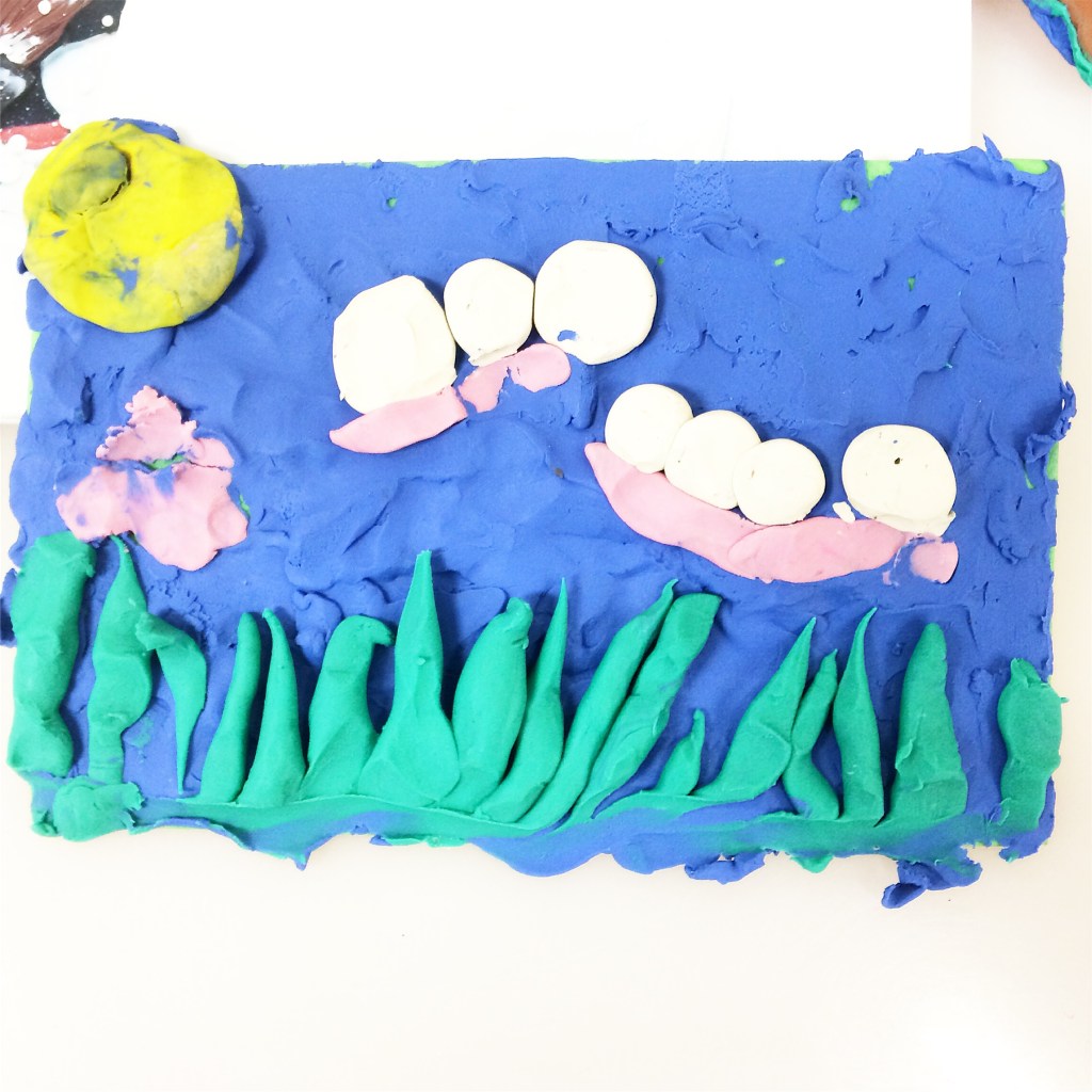 Playdough scene with moon, snails, flowers, and grass on blue background.